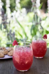 Poster Closeup of red strawberry lemonades with ice put on the table with cookies on blurred background © Jeffrey Bethers/Wirestock Creators