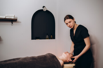 Portrait of smiling female masseuse in therapy salon with copy space.