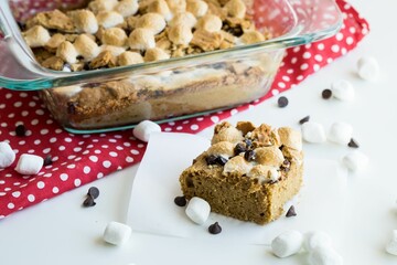 Closeup shot of freshly baked store cookies with chocolate and marshmallows on the white tablecloth