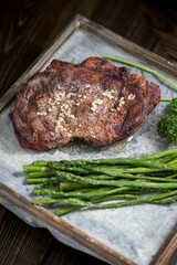 Closeup shot of roasted beef meat with asparagus put on the wooden table