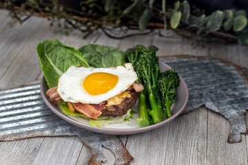 Healthy breakfast with egg, bacon, and lettuce leaves on the plate served at a restaurant
