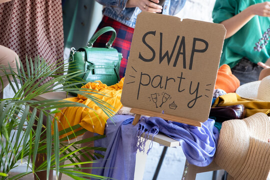 Young women at swap party. Choose casual clothes, shoes, hats, bags, jewellery. Idea of exchange your old wardrobe for new. Eco friendly cloth concept. Zero waste shopping, reduce and reuse, donation