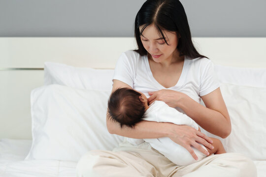 Mother is breast-feeding a newborn baby. Little baby girl breast