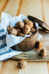 Vertical shot of the oatmeal cookie bites in a brown box on a wooden board