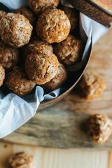 Vertical closeup shot of the oatmeal cookie bites in a brown box on a wooden board