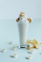 Vertical of the fresh caramel milkshake and a banana isolated on the empty white background