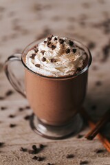 Vertical shot of a cup of hot chocolate on the wooden background