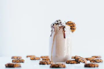 Fotobehang Closeup shot of a delicious cookie shake in a glass jar surrounded by cookies © Jeffrey Bethers/Wirestock Creators