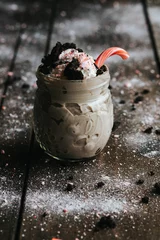 Deurstickers Closeup shot of a delicious cookie shake in a glass jar surrounded by icing sugar © Jeffrey Bethers/Wirestock Creators