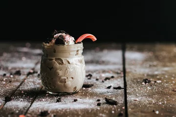 Fotobehang Closeup shot of a delicious cookie shake in a glass jar surrounded by icing sugar © Jeffrey Bethers/Wirestock Creators