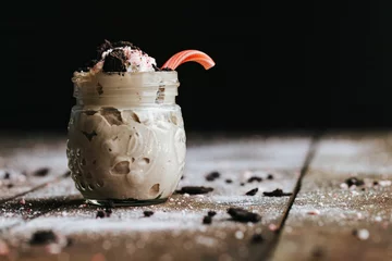 Deurstickers Closeup shot of a delicious cookie shake in a glass jar surrounded by icing sugar © Jeffrey Bethers/Wirestock Creators