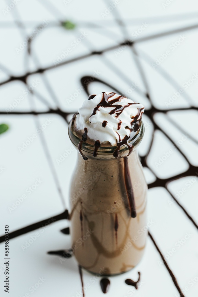 Sticker closeup shot of a cute mini glass bottle of chocolate milkshake topped with whipped cream