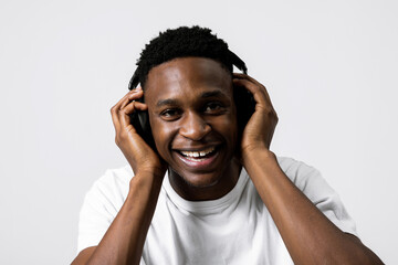 Portrait of happy delighted excited african american black guy model student posing over grey background in studio isolated singing listening to music while posing for shooting process.