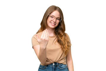 Young pretty woman over isolated background inviting to come with hand. Happy that you came