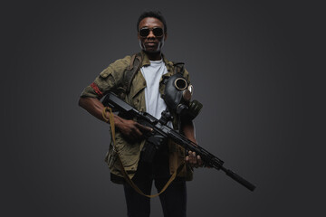 Studio shot of somali pirate man dressed in uniform posing agianst gray background.