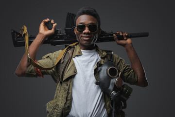 Portrait of handsome somali gangster holding rifle on his shoulders. - obrazy, fototapety, plakaty