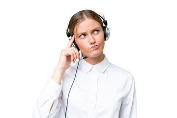 Telemarketer caucasian woman working with a headset over isolated background having doubts and with confuse face expression