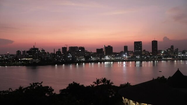 Beautiful shot of the illuminated Abidjan skyline under a sunset sky in Cote d'Ivoire