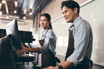 Cafe handsome Asia man and woman waitress cashes in order bill register working happy at coffee shop