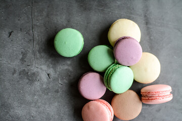 Colorful and sweet macaroon cookies on dark background