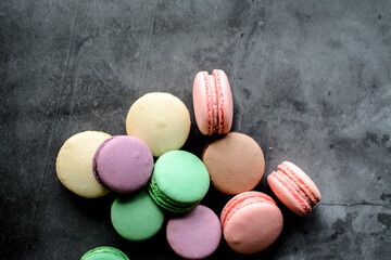 Colorful and sweet macaroon cookies on dark background