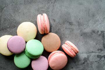 Colorful and sweet macaroon cookies on dark background