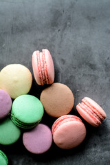 Colorful and sweet macaroon cookies on dark background