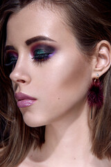 Fototapeta premium Beautiful woman with bright multicolor celebration make up Chic evening make-up. Fashion retouched portrait.
