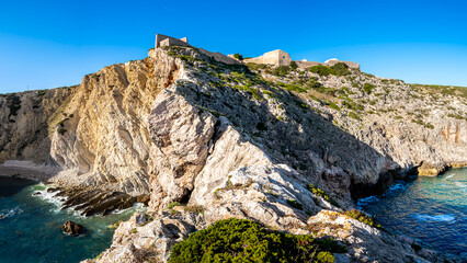A breathtaking panoramic view captures the rugged beauty of a ragged cliff with the ruins of fort...