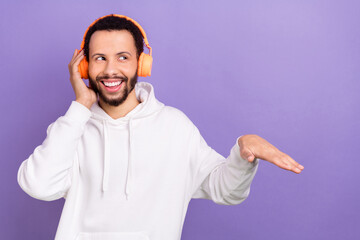 Fototapeta premium Photo of excited funky person hand touch headphones look empty space isolated on violet color background