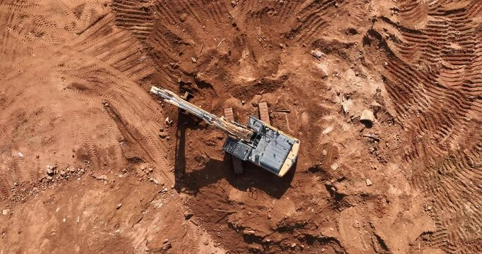 Aerial footage of Wheel Loader and a bagger working on a hill at a construction site and preparing the area for construction work. Filmed in C4K Apple ProRes 422 HQ