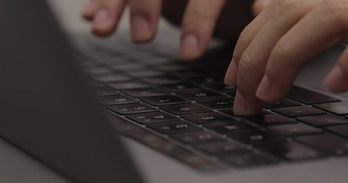 hand typing on laptop keyboard. close-up shot of finger using track pad