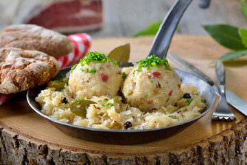 Deftige Südtiroler Speckknödel auf Sauerkraut rustikal in der Eisenpfanne serviert – Delicious...