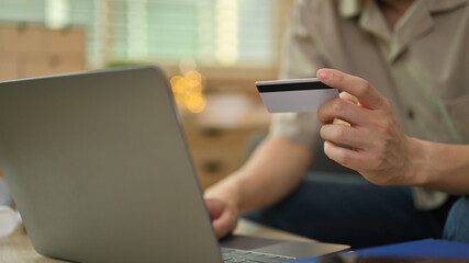 Man holding credit card and using mobile phone for online banking transaction. Business financial...