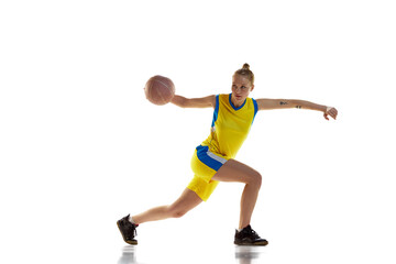 Fototapeta na wymiar Concentration and motivation to win. Young girl, basketball player in motion, training against white studio background. Concept of professional sport, hobby, healthy lifestyle, action and motion