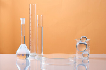 A petri dish upside down form an empty platform to display product and lab glassware, glass ball...