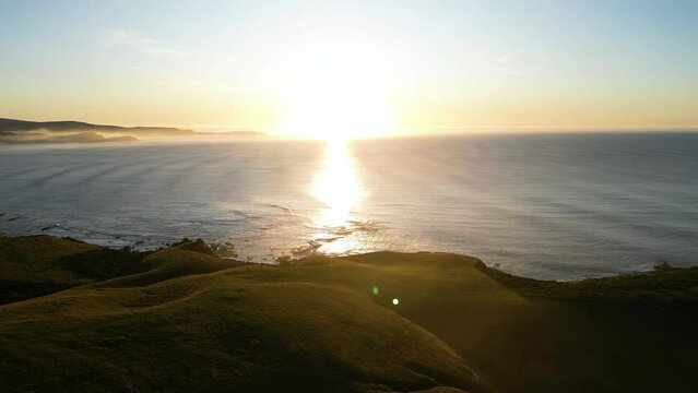 Balclutha aerial view of scenic seascape over the ocean in New Zealand epic sunset with green lush natural hills
