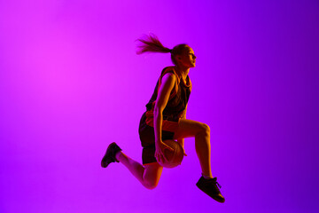Fototapeta na wymiar Dynamic image of female basketball player, young girl training with ball against white studio background. Concept of professional sport, hobby, healthy lifestyle, action and motion