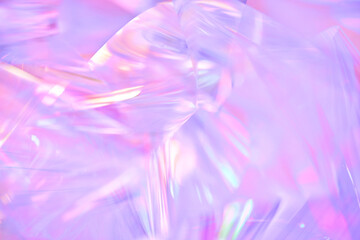 Naklejka na ściany i meble Close-up of ethereal pastel neon pink, purple, lavender, mint holographic metallic foil background. Abstract modern curved blurred surreal futuristic disco, rave, techno, festive dreamlike backdrop