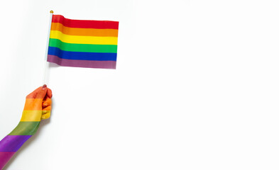 Fototapeta premium gay pride and lgbtq festival concept. pride flag in hand on white background