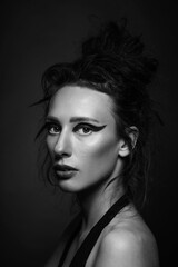 Fashion and make-up concept. Studio portrait of beautiful woman with red shadows, long and dark dreadlocks hair looking at camera with seductive look. Studio shot. Black and white image