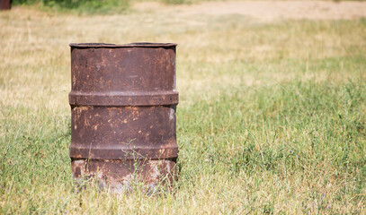 Obraz premium rusty garbage container on grass or meadow. copy space for text. focus on the garbage