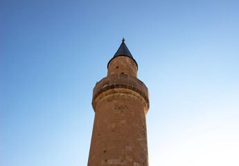 mosque minaret on clear blue sky. old stone historic ottoman style minaret