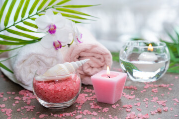 Starfish, seashells, terry towel, candle and plant on the sand. Spa and wellness concept