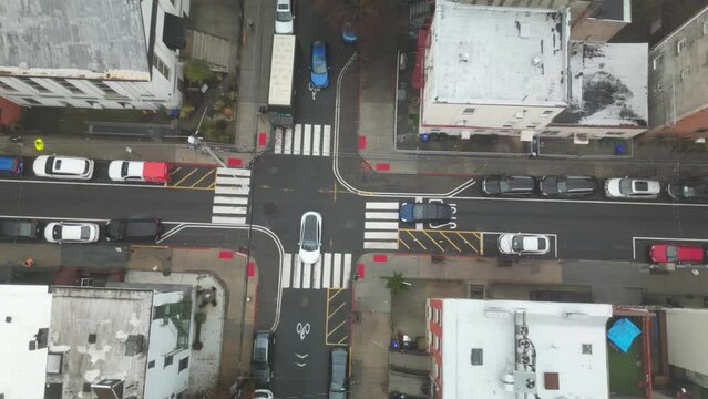 A busy street road in Hoboken, New Jersey, with a cityscape and parked cars on a foggy day, top view