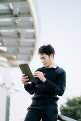 Handsome young businessman using a digital tablet outside an office building.