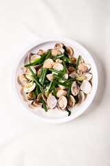 braised fresh White Sea clam shell in Chinese wine ginger onion and scallion soup in white bowl on wood table luxury halal food fine dining restaurant seafood menu