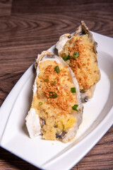 fresh western seafood steamed 2 big oyster shell with garlic ginger sauce in white plate on wood table luxury halal food fine dining restaurant menu