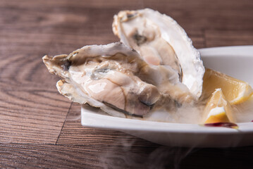fresh western seafood raw big oyster shell with lemon in white cold plate on wood table luxury halal food fine dining restaurant menu