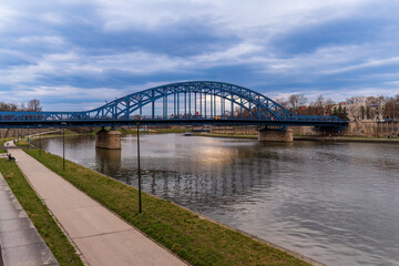 Jozef Pilsudski Bridge, the oldest road bridge across the Vistula in Krakow connects Kazimierz and Podgórze, Krakow Technique Way tourist route, cloudy spring day, street photography